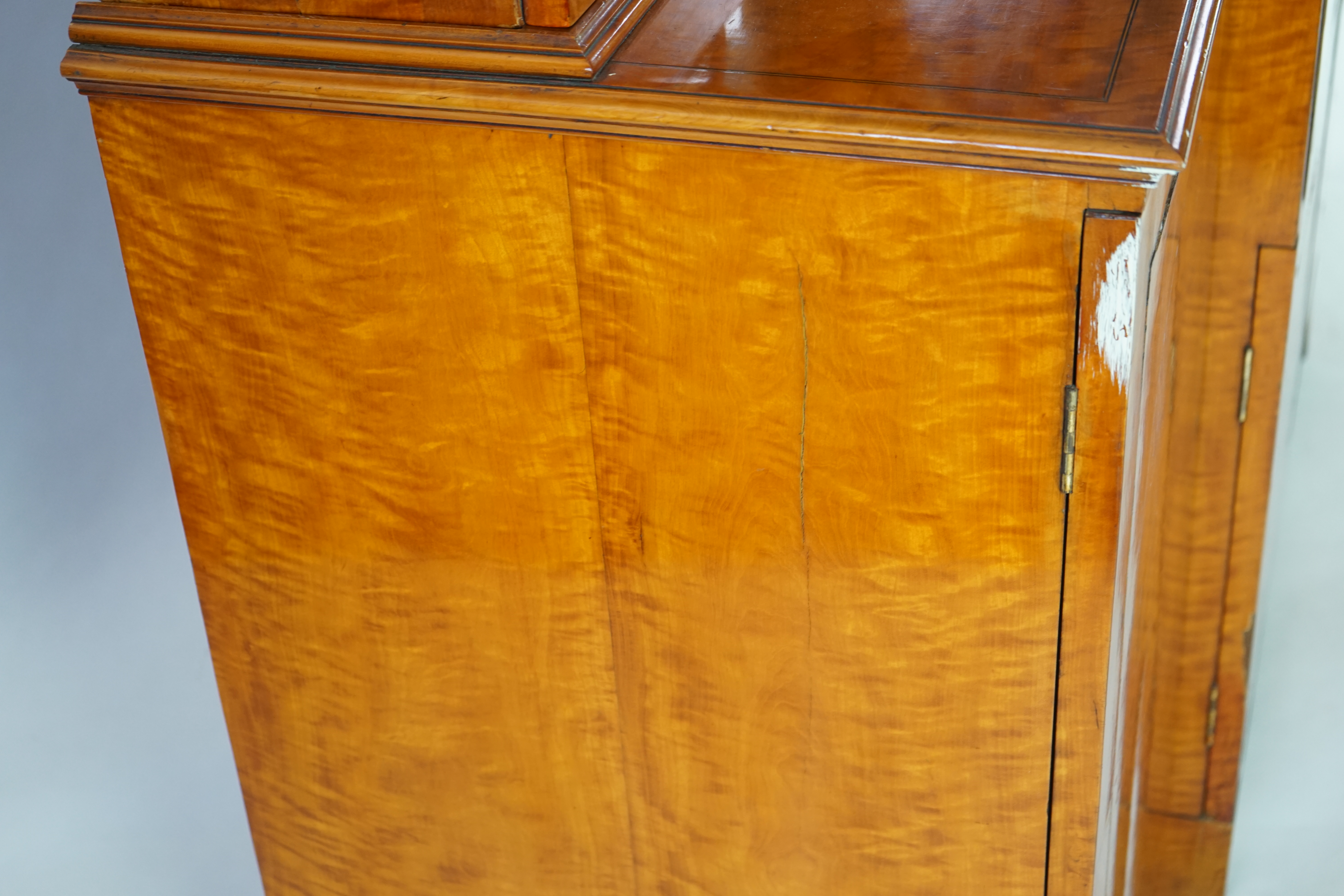 A Sheraton revival ebony strung satinwood breakfront secretaire bookcase